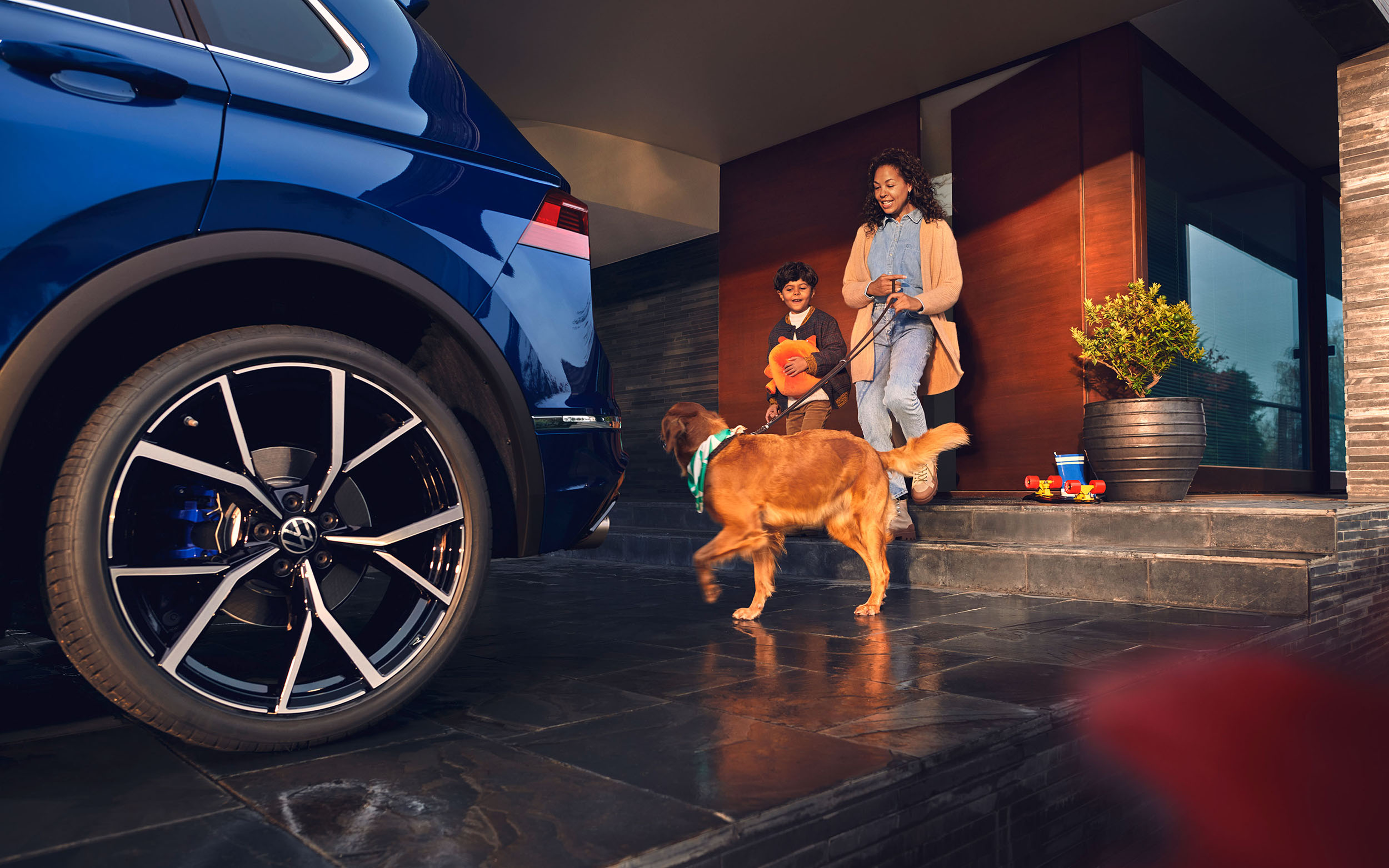 Familie mit Hund hinter Auto