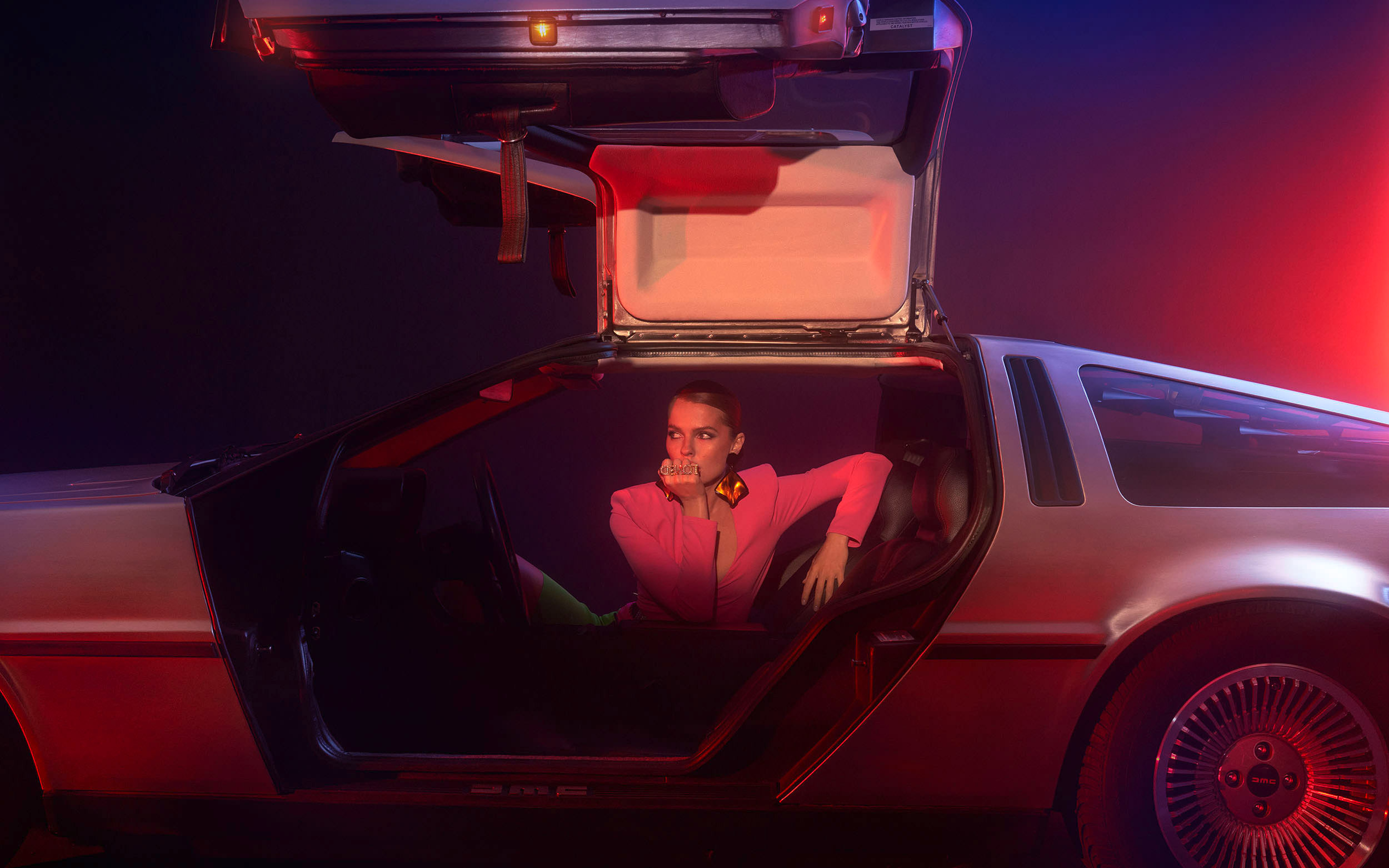 Frau sitzt in Delorian DMC